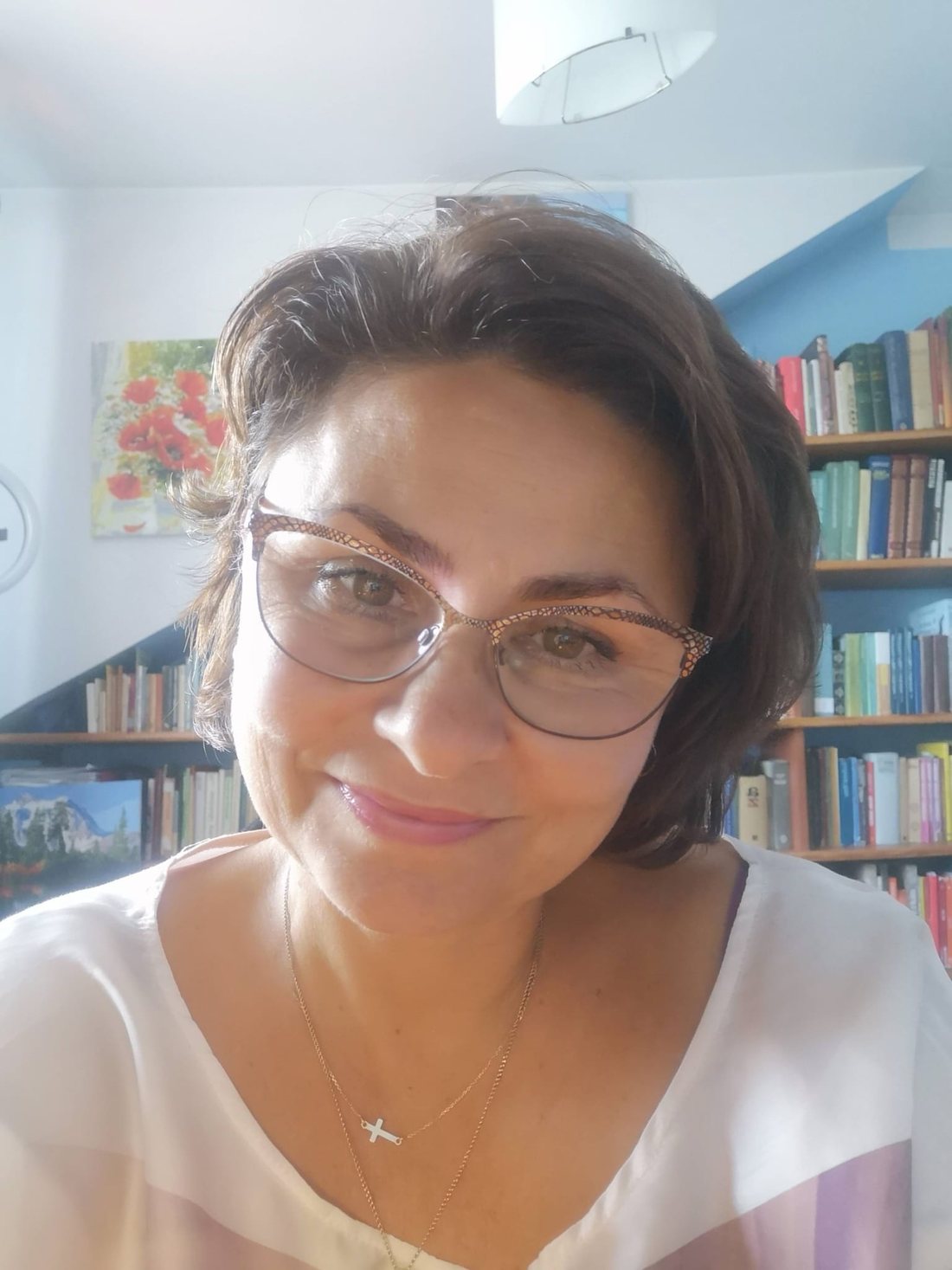 Jolanta Sobowska, викладачка польської мови, усміхається на тлі книжкових полиць